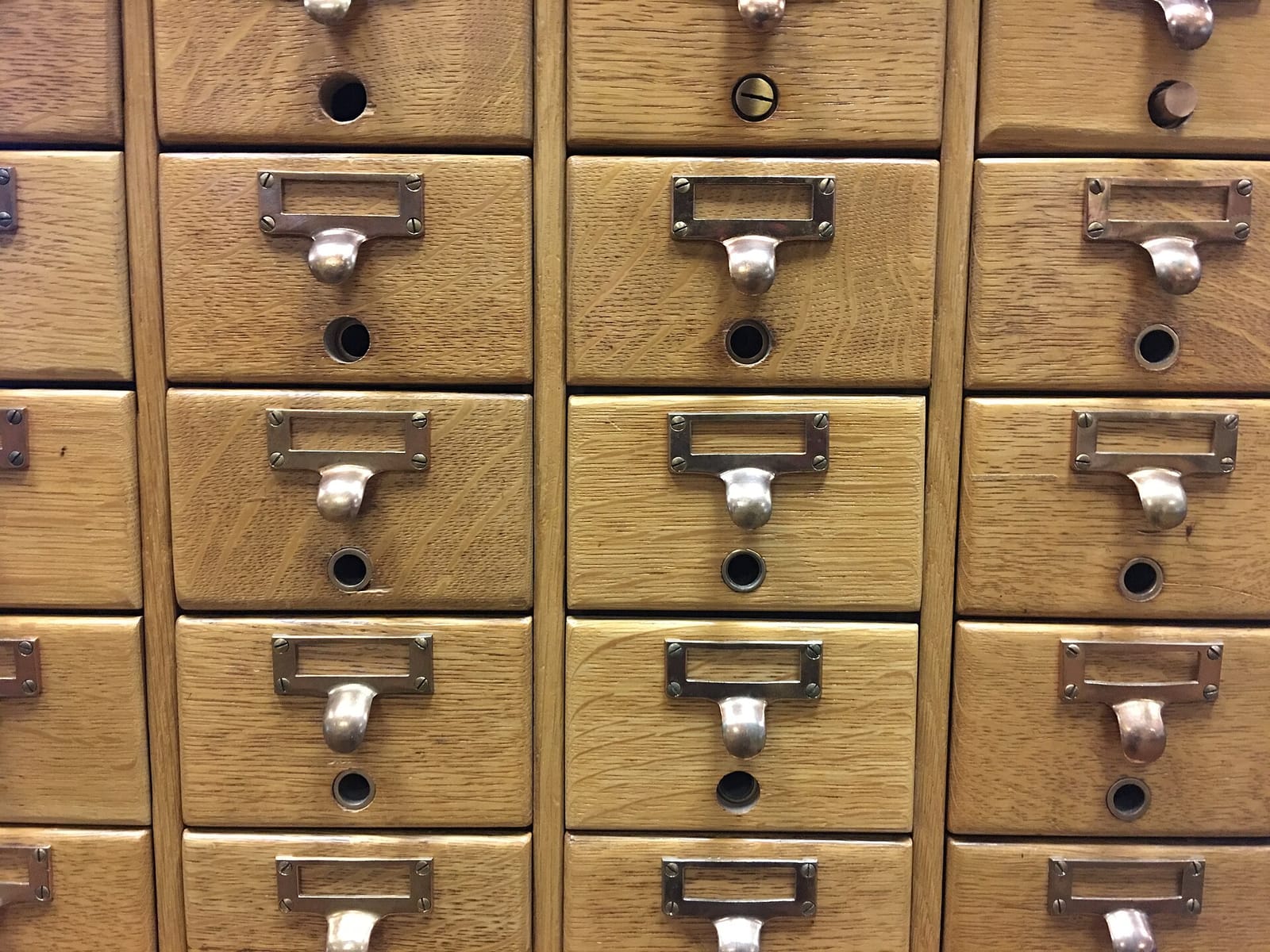 Close-up of wooden card catalog drawers with metal handles