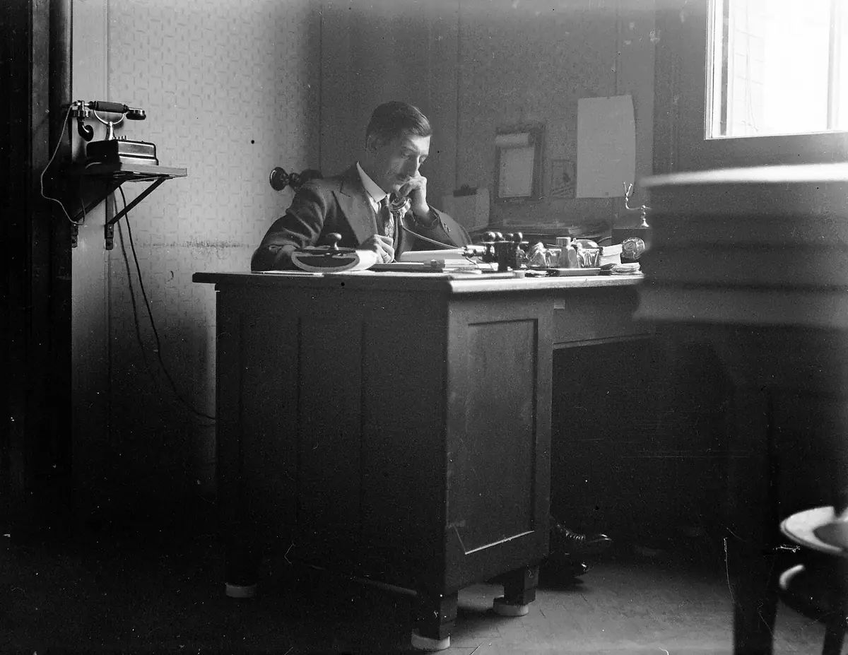 A tidy office desk with a telephone and an ink blotter