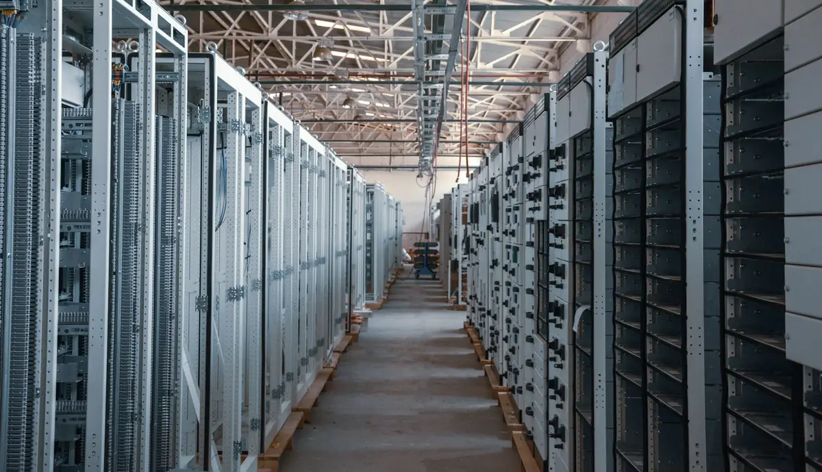 An aisle between metal equipment racks in a server room
